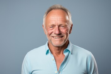 Fototapeta premium Portrait of a grinning man in his 50s donning a classy polo shirt isolated on pastel gray background