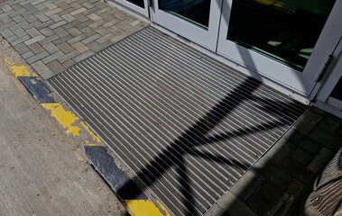 industrial mat cleaning zones at the entrance to the building. black plastic-metal mat in the shape...