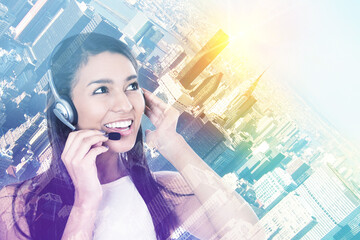 Portrait of a businesswoman in a headset on a cityscape background  - 787063164
