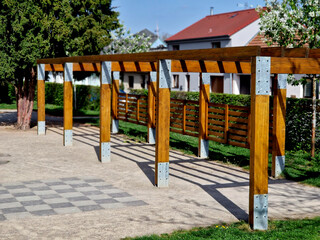 terrace with wooden pergola and plexiglass roof. vines are straining, crawling under the beams. garden or park. sitting with dry wall wine region. restaurant countryside france, truss