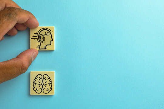 Hand choosing wooden cube with AI(Artificial intelligence) icon among human brain icon concept for futer technology,Artificial intelligence,AI.