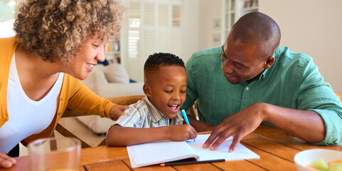 Family Indoors At Home With Grandmother And Father Drawing Picture With Son 