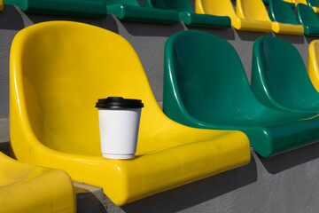 white paper cup of coffee in the stands of the stadium