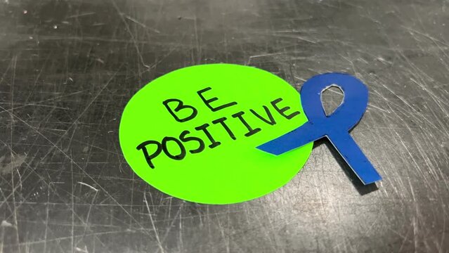 Video of a green sticker with the word "be positive" written on it
