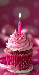 A delightful pink cupcake topped with creamy frosting and a single lit candle, surrounded by heart confetti on a matching pink background.
