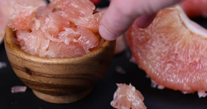 peeled red and pink pomelo on the table, citrus pomelo peeled and folded on the table