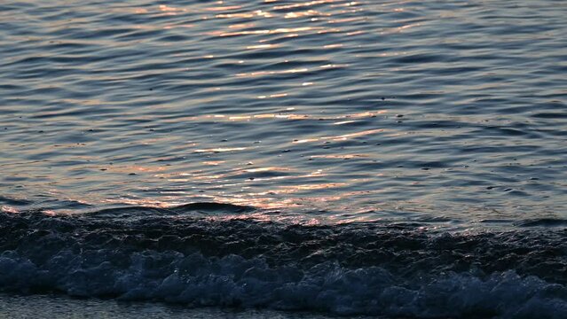 Sparkling water texture. Waves in the sea at sunrise.