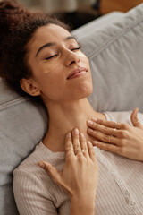 Vertical closeup of young Middle Eastern woman enjoying face and neck massage and self care day - 787080147