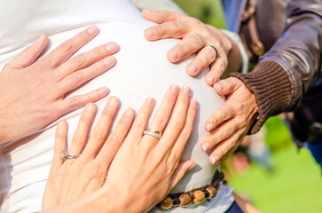 Single mother not alone. Hands on a pregnant woman's belly meaning they are going to help the...