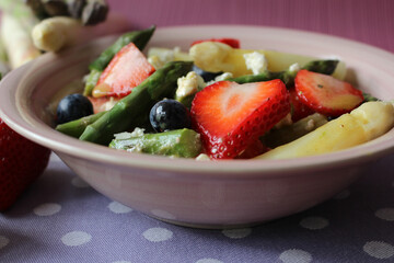 Springtime Delight: Strawberry, Asparagus, and Feta Salad with Honey Mustard Dressing on a Pink Background
