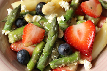 Springtime Delight: Strawberry, Asparagus, and Feta Salad with Honey Mustard Dressing on a Pink Background