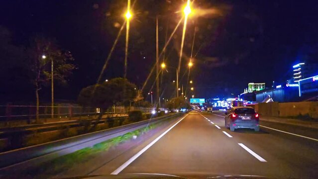 a car driving down a street at night