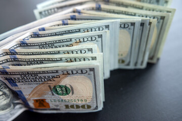 american hundred dollar bills banknotes lies on black desk