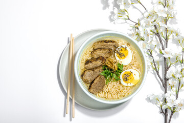 Japanese noodles Ramen with broth. Hot dish, duck, egg, greens, hard light, dark shadow