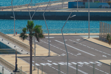 Road markings, directional arrows, divided lanes of carriageway, road going to marina, harbor - obrazy, fototapety, plakaty