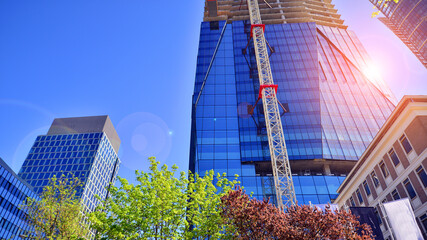 High rise building under construction. Installation of glass facade panels on a reinforced concrete...