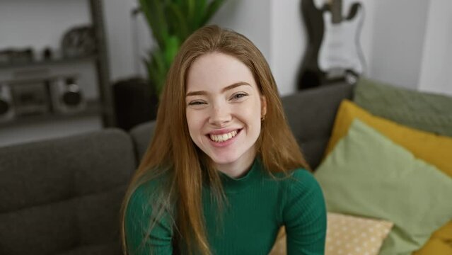 Cheeky home fun, young blonde woman wearing a sweater puffing cheeks in crazy expression, filling mouth with air for hilarious grimace in living room.