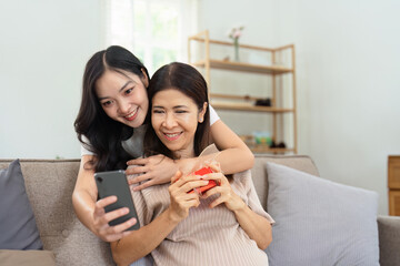 Congratulations. Loving asian mature daughter surprised mother with present in Mother's Day, giving...