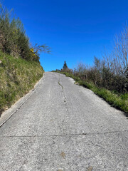 Empty asphalt road on the Camino del Norte in Spain leading up a hill on a sunny day