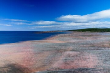 Intentional camera movement (ICM) image of a dream like background of rocky seashore created by motion blur.
