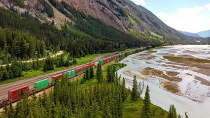 Train passes along river. Mountain river flowing through forest during flash flood from mountains.