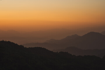 nature traveling with orange sky and layer of mountain with sunrise background