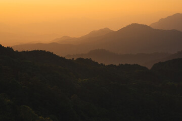 nature traveling with orange sky and layer of mountain with sunrise background