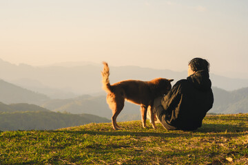 nature traveling with solo man play with dog and see sunrise with layer of mountain