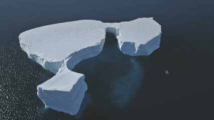 Aerial Overview Of Iceberg Among Antarctica Ocean. Drone Flight Over Huge Ice Mountain. Sunlit Cold Ocean Water. Winter Antarctic Landscape. Wilderness. Virgin Nature.
