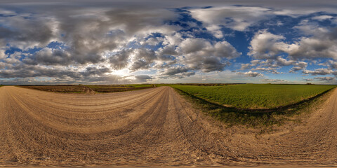 360 hdri panorama view on no traffic gravel road among fields in spring day with beautiful clouds...