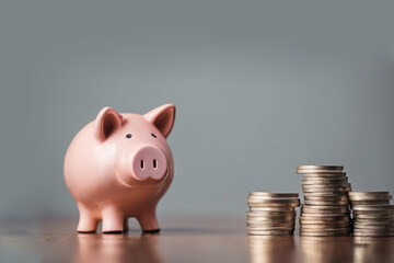 Ceramic piggy bank next to stacks of coins on a neutral background, AI generated