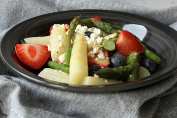 Harmony in Contrast: Strawberry, Asparagus, and Feta Salad with Honey Mustard Dressing on a Grey Background