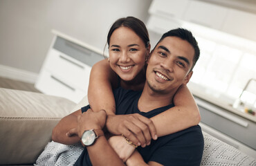 Portrait, smile and Asian couple in home to relax for love, care and hug on sofa in living room....