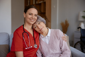 Smiling happily caregiver hugging her old lady patient portrait - 787133147