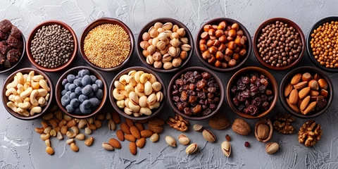 Fotobehang Wooden bowls filled with a variety of healthy nuts including cashews, walnuts, almonds, hazelnuts and pistachios. © Iryna