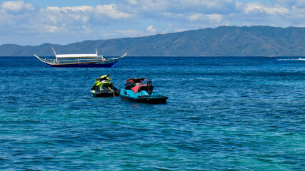 Jet skis and motor boat at sea. Two jet skis and a motor boat on the open sea against the backdrop...
