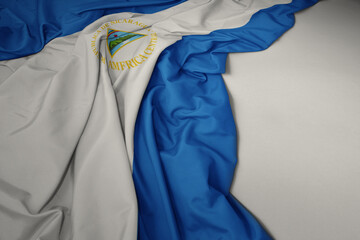 waving national flag of nicaragua on a gray background.
