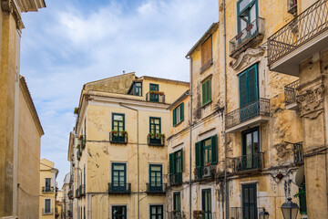 Salerno, Italy historic buildings with iron balconies and wooden window shutters under a sky with...