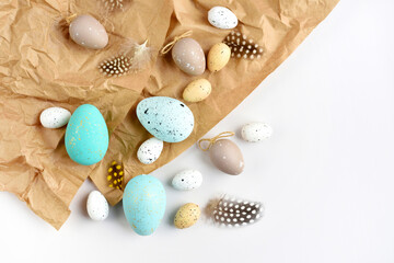 Easter eggs and feathers on a brown kraft paper background on a white table. Top view. For easter greeting cards with copy space. - 787152112