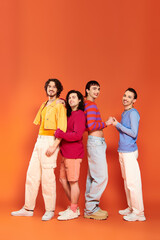 Fototapeta premium four debonair appealing cheerful gay men in vibrant clothes posing together actively, pride month