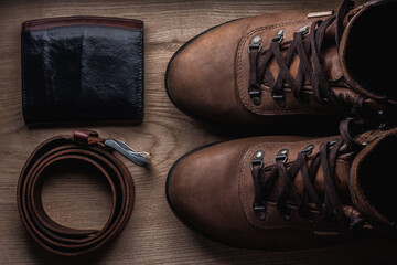 Boots, belt, wallet on wood table stil life