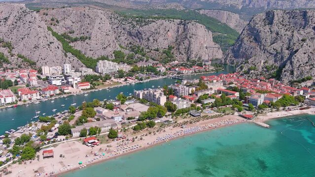 Omis, Croatia: Aerial view of famous Mediterranean town and summer resort by Adriatic Sea, Punta Beach (Velika plaža) summer day with clear blue sky - landscape panorama of Europe from above
