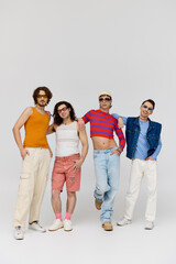 Fototapeta premium four fashionable cheerful gay friends with stylish sunglasses posing actively together, pride month