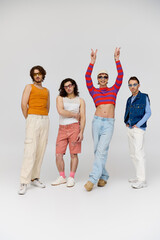 Obraz premium four elegant cheerful gay friends with stylish sunglasses posing actively together, pride month