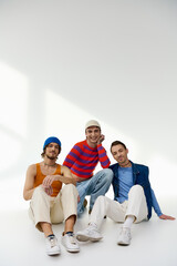 positive lgbtq friends in vibrant attires posing together on gray backdrop and smiling at camera