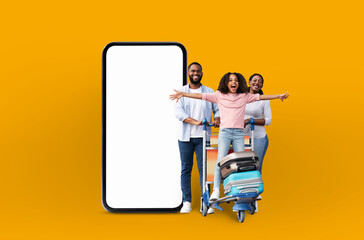 African american family with luggage standing by blank mobile screen