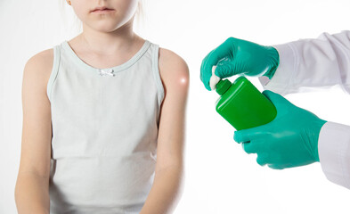 Doctor's hands with cotton wool and antiseptic treating the skin before vaccination against tetanus and viral hepatitis. Revaccination of children, hemophilus influenzae infection