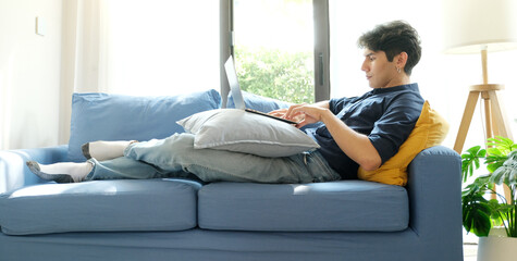 Young man working with laptop computer at home, work from home, online learning