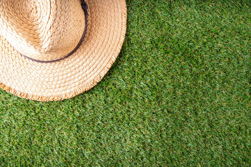 Spring, summer picnic, outdoor recreation background. A woman's straw hat, a picnic blanket or tablecloth, sunscreen spray, an apple on a background of green artificial grass or lawn, copy space - 787166963