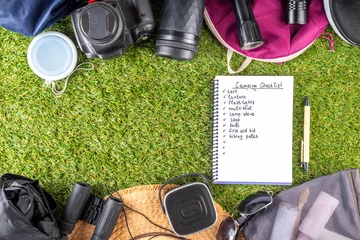 Foto auf Acrylglas Camping checklist with various camp equipment. List of things for outdoors recreation and travel in nature - tent, first aid kit, cosmetics, accessories, equipment, clothes, trekking shoes © ricka_kinamoto